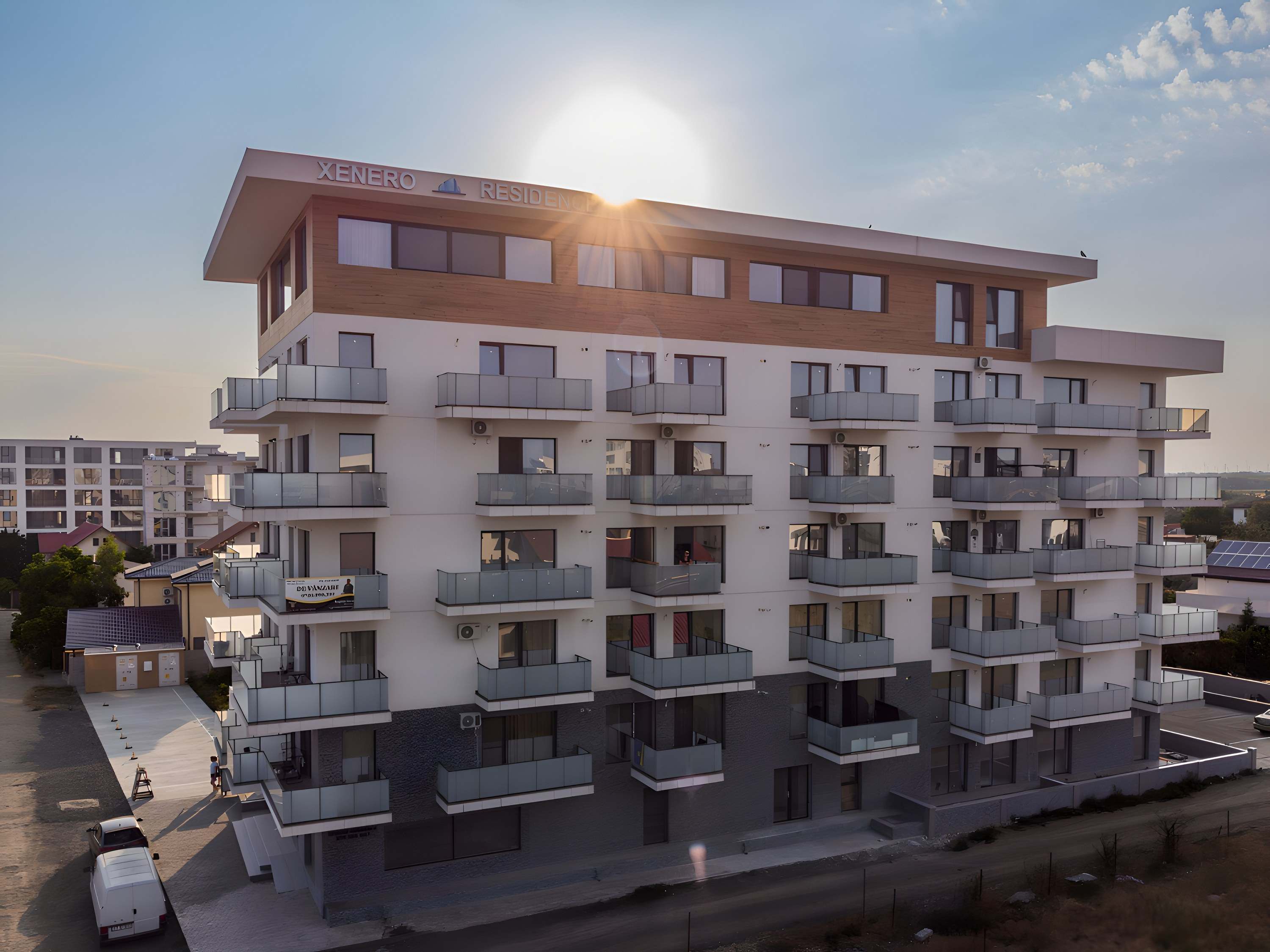 Clădirea XENERO Residence, cu etajul superior placat cu lemn, în lumina de apus